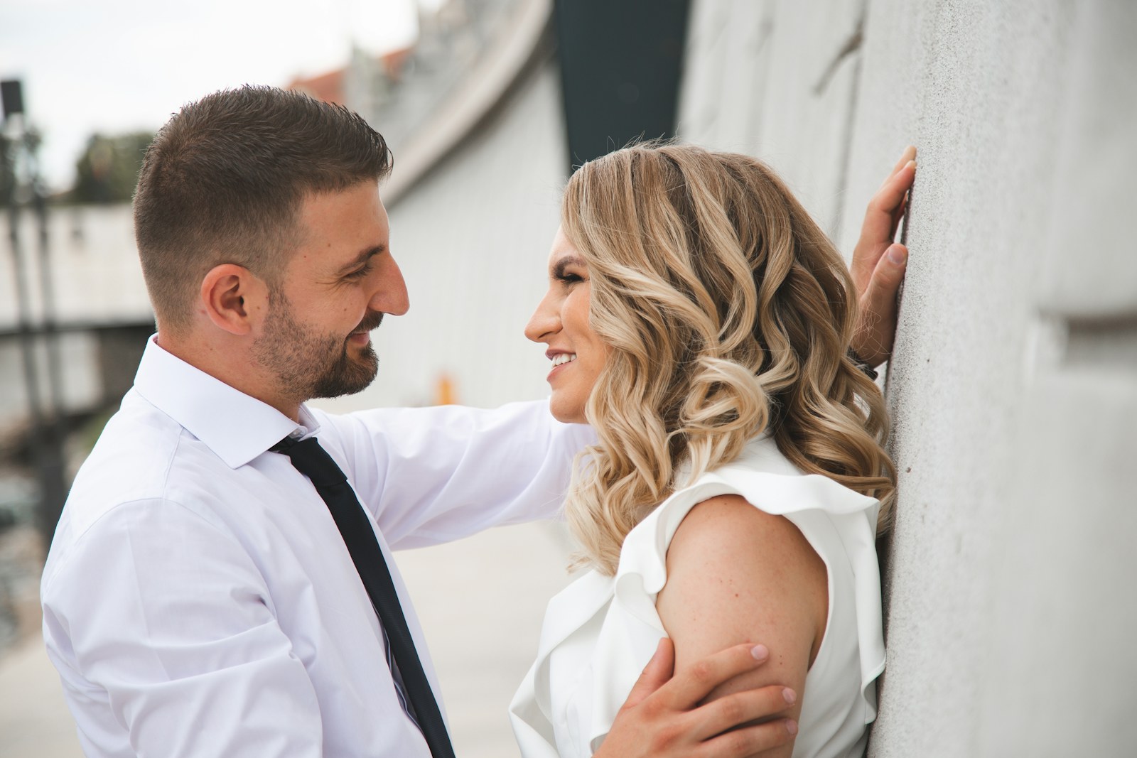 Couple smiling at one another outdoors